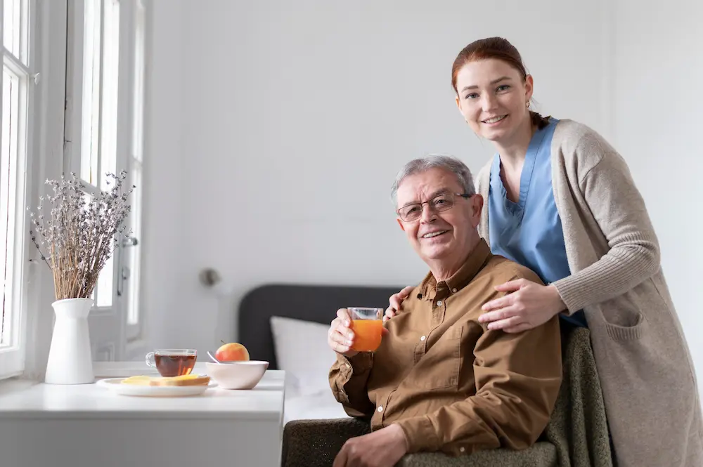 Caregiver and elderly man smiling on a porch swing