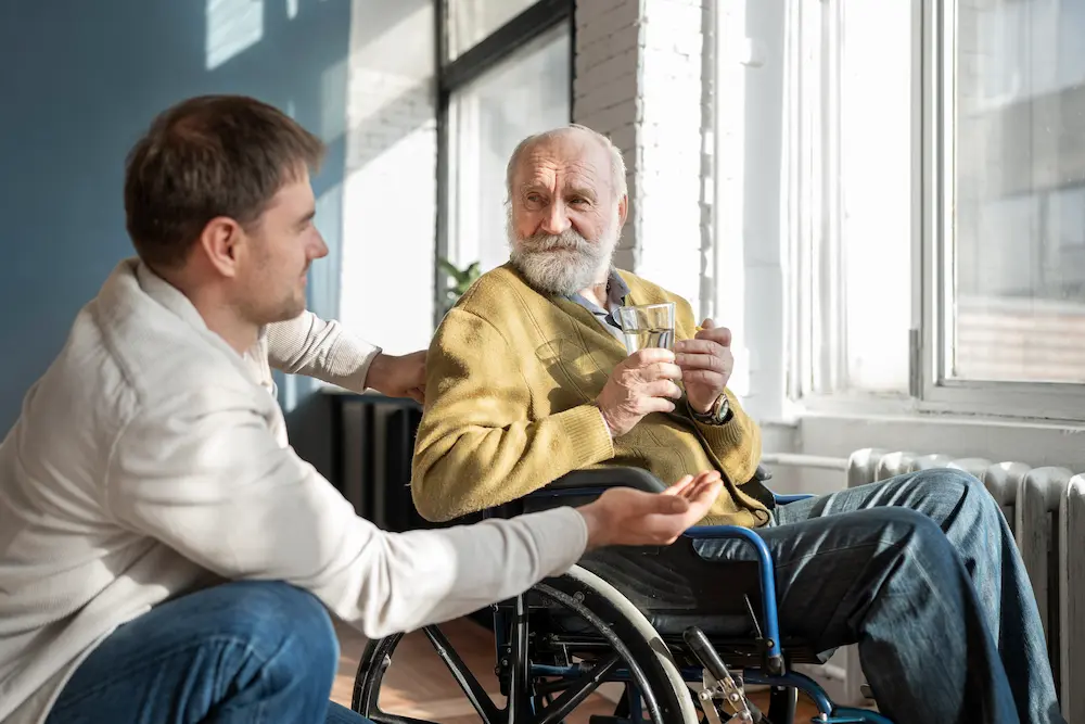 Caregiver and elderly man smiling on a porch swing
