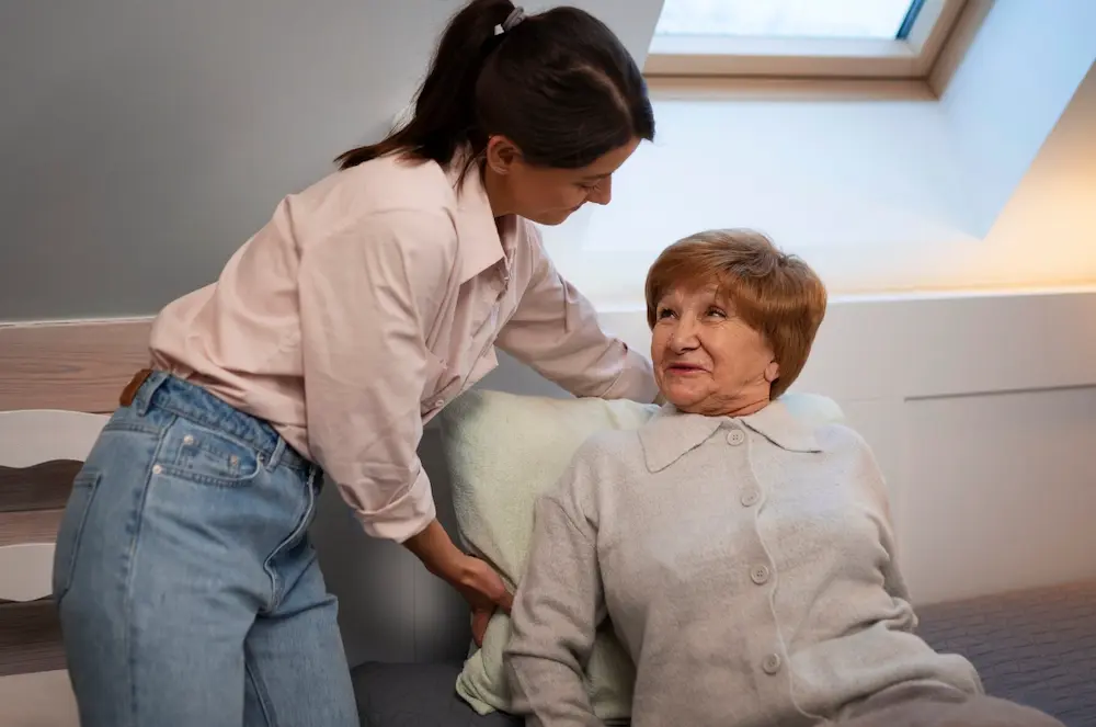Caregiver and elderly man smiling on a porch swing