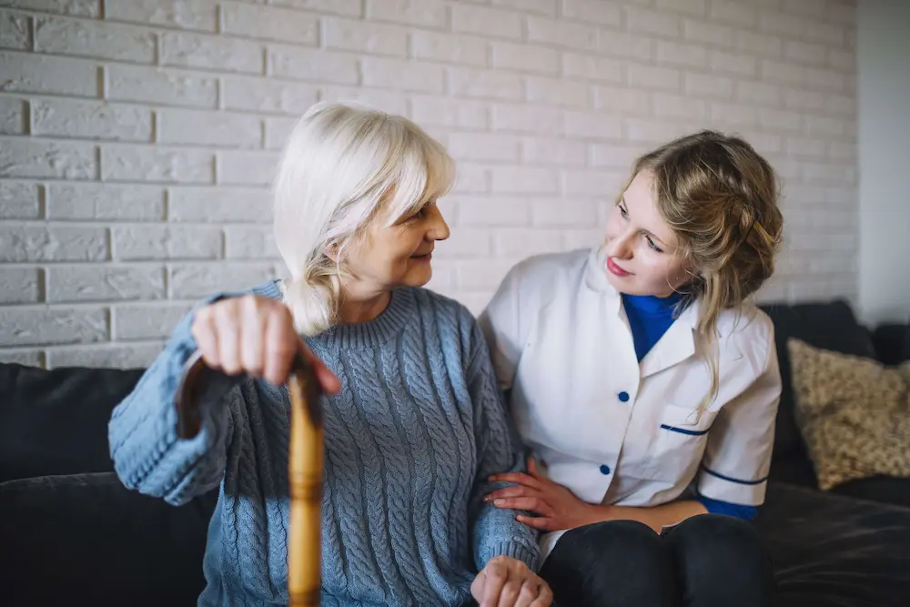 Senior woman smiling with her compassionate nurse