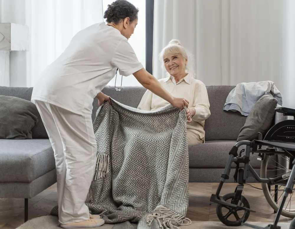 Caregiver helping an elderly man choose a sweater