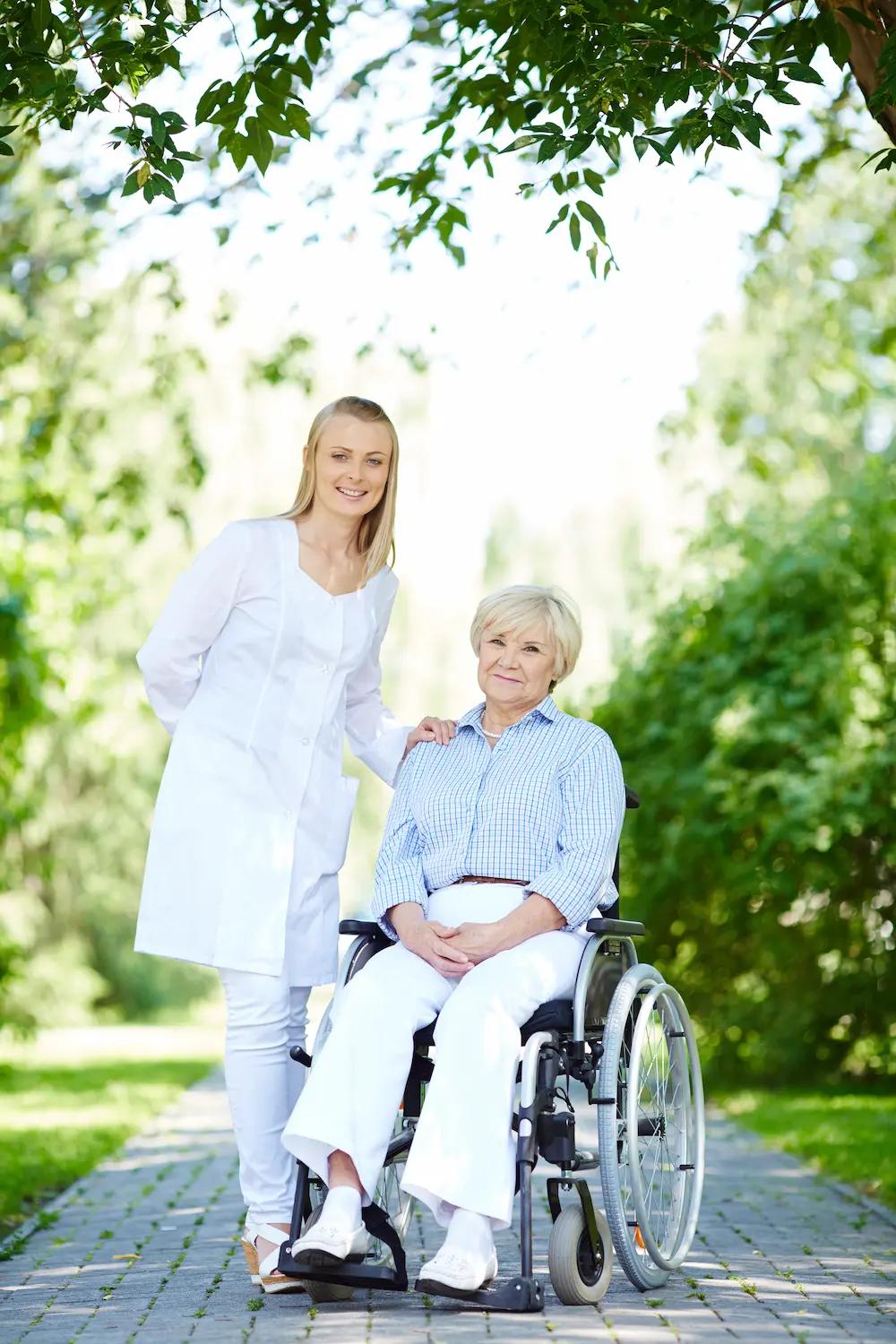 Caregiver with an elderly woman among trees